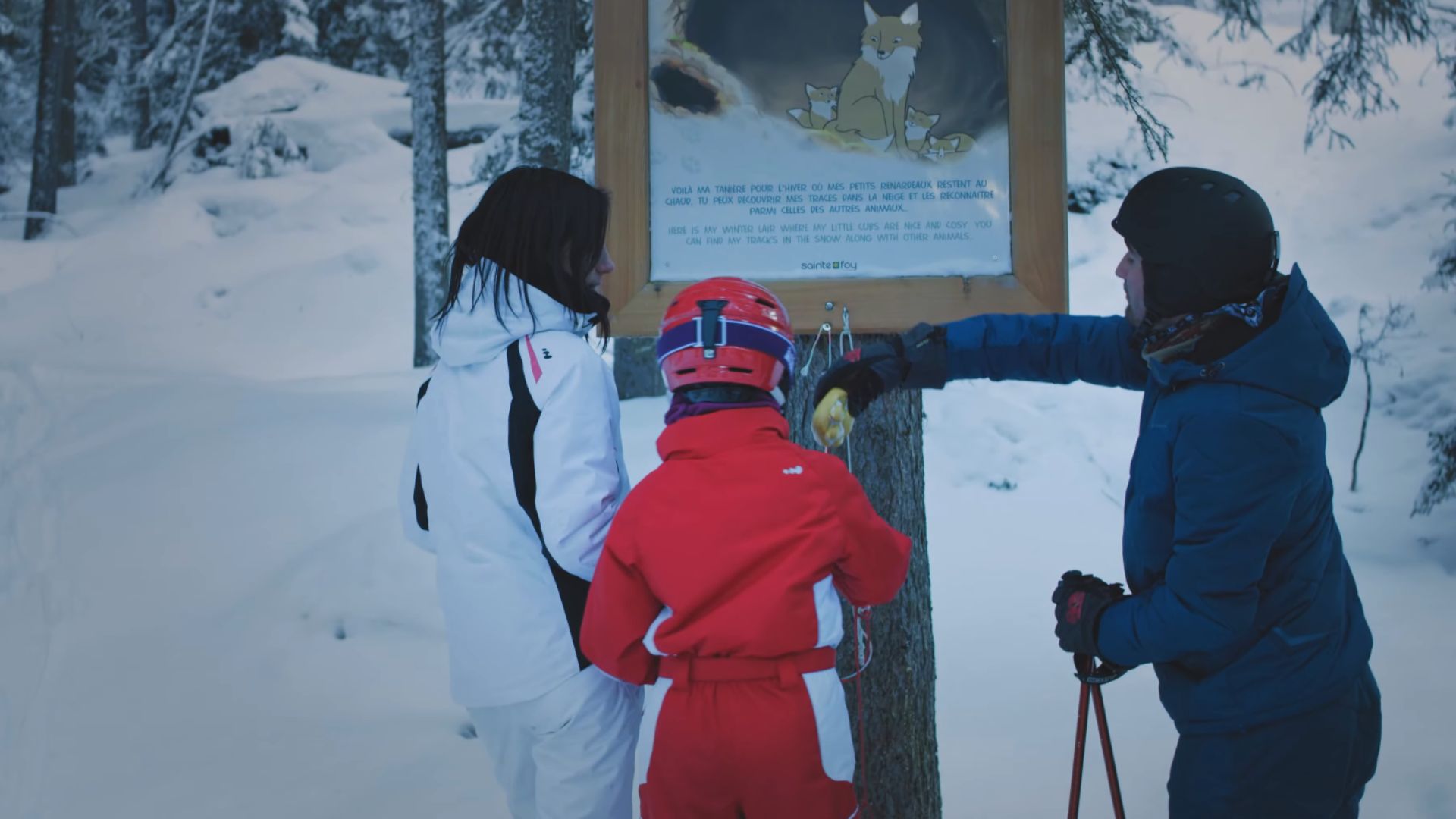 Famille au ski devant un panneau Natur'Protect
