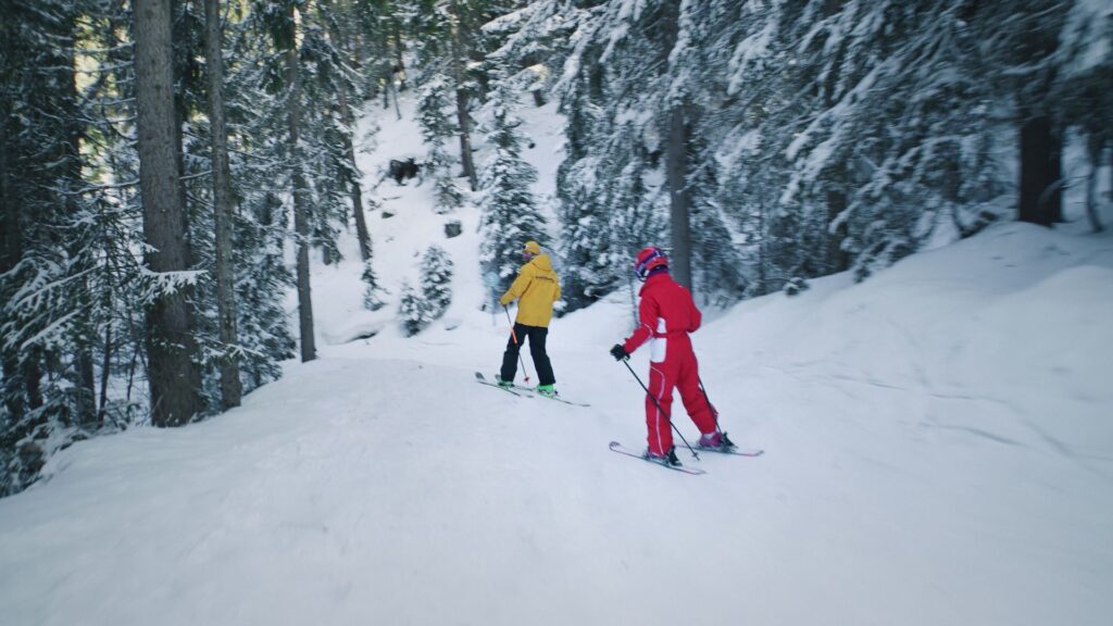 enfant qui suis son moniteur sur une piste en forêt